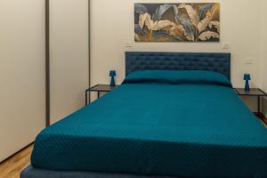 a bedroom with a blue bed with two tables at La Casa al Centro in Policoro