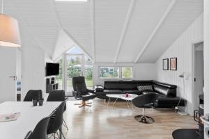 a living room with a black couch and chairs at M300-Vaeggerlose-Stolt-Henriksvej-53 in Bøtø By