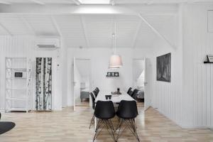 a white living room with a table and chairs at M300-Vaeggerlose-Stolt-Henriksvej-53 in Bøtø By