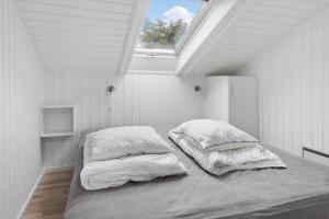 a bedroom with two pillows on a bed with a window at M300-Vaeggerlose-Stolt-Henriksvej-53 in Bøtø By +19 photos