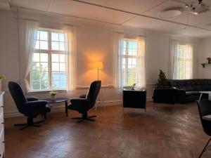 a living room with a couch and chairs and windows at Hotel Carl XII in Ed