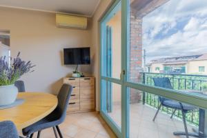a room with a table and a balcony with a television at Gina Gedici Resort in Gedići