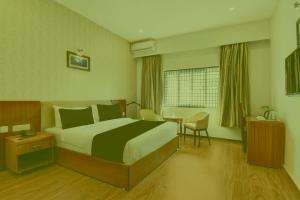 a hotel room with a bed and a table at Prabin Ghatiya Homeinn in Patna