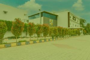 a building with a row of trees in front of it at Prabin Ghatiya Homeinn in Patna