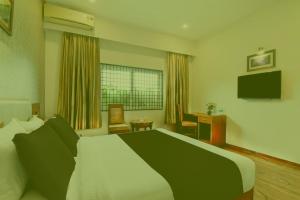 a bedroom with a large bed and a desk at Prabin Ghatiya Homeinn in Patna