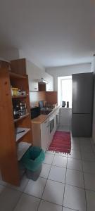 a kitchen with a refrigerator and a tile floor at Ela Gar 3 WG Zimmer in Garsten