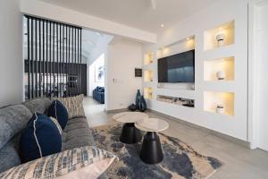a living room with a couch and a tv at Villa Solis - Elegant & Modern Private Pool Escape in Cap Malheureux