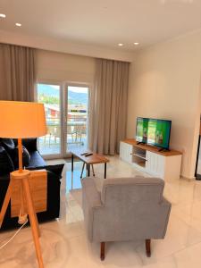 a living room with a couch and a television at Thea Suite & Loft in Kavála
