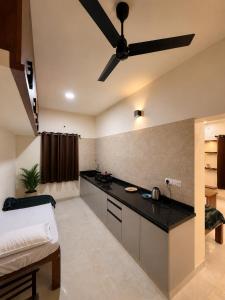 a bedroom with a bed and a ceiling fan at Pinto Eden Home Stay 5 Star Luxury Stay in Chikmagalur in Sangameswarpet