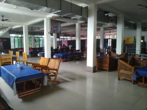a restaurant with tables and chairs and people in the background at Natraj hotel rooms and restaurant in Motīnāla