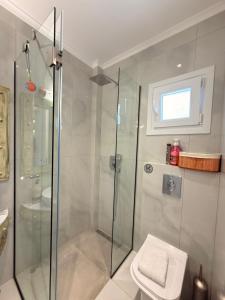 a bathroom with a glass shower and a toilet at Thea Suite & Loft in Kavála +26 photos