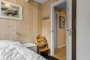 a bedroom with a bed and a chair in it at 146-Ringkobing-Hvidbjergvej-23 in Søndervig