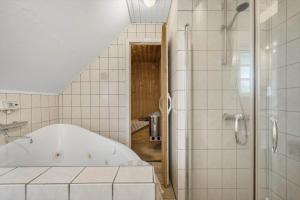 a white bathroom with a tub and a shower at 146-Ringkobing-Hvidbjergvej-23 in Søndervig +34 photos