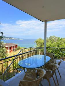 a balcony with a blue table and chairs and the ocean at Thea Suite & Loft in Kavála
