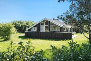 a black house on a green field with trees at LF403-Hurup-Thy-Klydevej-6 in Sindrup