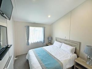 a bedroom with a large bed and a window at The Retreat 22 - Ukc9564 in Ingoldmells