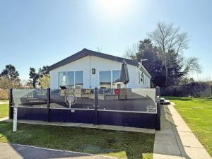 a house with a fence and an umbrella at The Retreat 22 - Ukc9564 in Ingoldmells