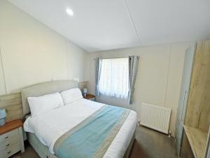 a bedroom with a white bed and a window at The Retreat 22 - Ukc9564 in Ingoldmells