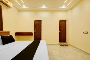 a bedroom with a bed with two doors in it at HOTEL O VILLAGE in Rāipur