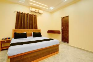 a bedroom with a bed and a window at HOTEL O VILLAGE in Rāipur +25 photos