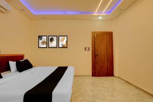 a bedroom with a bed and a wooden door at HOTEL O VILLAGE in Rāipur