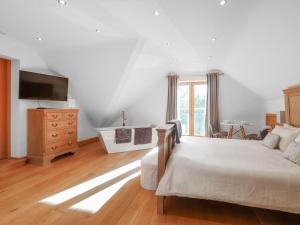 a bedroom with a bed and a dresser and a television at High View House in Kemeys Inferior +21 photos