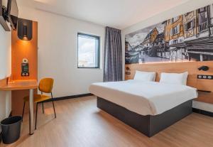a hotel room with a bed and a desk at B&B HOTEL Colmar Expo in Colmar