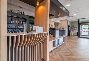 a bar in a restaurant with a wooden wall at B&B HOTEL Colmar Expo in Colmar +19 photos