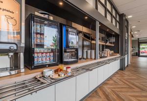 a fast food restaurant with a counter with food at B&B HOTEL Colmar Expo in Colmar