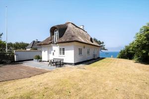 a house with a thatched roof on a yard at 1523-Vejby-Store-Orebjergvej-53-B in Vejby
