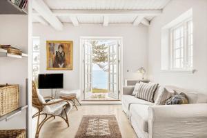 a white living room with a couch and a tv at 1523-Vejby-Store-Orebjergvej-53-B in Vejby