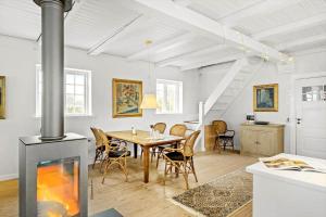 a dining room with a fireplace and a table at 1523-Vejby-Store-Orebjergvej-53-B in Vejby