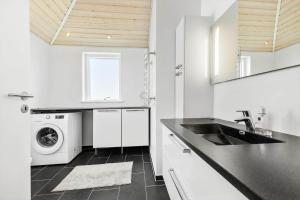 a white kitchen with a sink and a washing machine at 8302-Kolind-Falkevej-34 in Kolind +14 photos