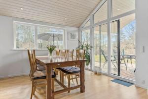 a dining room with a wooden table and chairs at 8302-Kolind-Falkevej-34 in Kolind