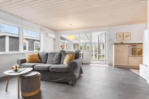 a living room with a gray couch and a kitchen at LF15081-Farso-Illeris-121 in Farsø