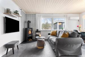a living room with a couch and a fireplace at LF15081-Farso-Illeris-121 in Farsø