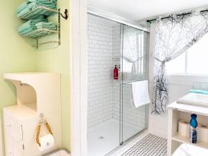 a bathroom with a shower and a toilet and a sink at Whimsea Cottage in Twillingate