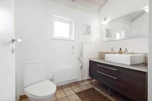 a white bathroom with a sink and a toilet at 84174-Knebel-Fuglsovig-301 in Knebel +19 photos