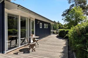 a wooden deck with a table and chairs on it at 84174-Knebel-Fuglsovig-301 in Knebel