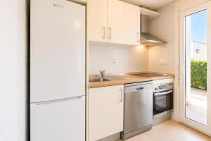 a kitchen with white cabinets and a sink at Adosado Roldán by Rental Olé in Roldán