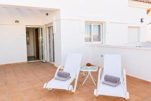 a patio with two chairs and a table at Adosado Roldán by Rental Olé in Roldán