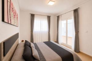 a bedroom with a bed and a large window at Adosado Roldán by Rental Olé in Roldán +8 photos