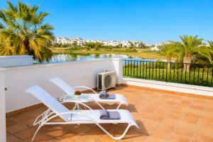 a balcony with two chairs and a table and a computer on it at Adosado Roldán by Rental Olé in Roldán