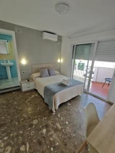a large bedroom with a bed and a balcony at AYAMONTE ROOMS 43 in Ayamonte