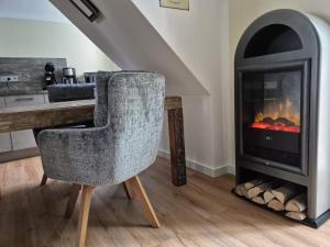 a living room with a chair and a fireplace at Rügenglück in Breege