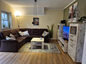 a living room with a brown couch and a coffee table at Rügenglück in Breege