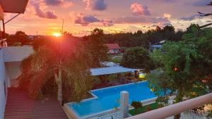 a sunset over a swimming pool on a house at 449 Airport Phuket in Nai Yang Beach