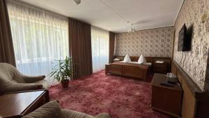 a living room with a bed and a couch at Hotel Turist in Chişinău +11 photos