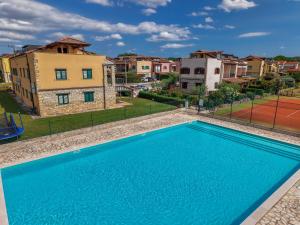 a blue swimming pool in front of some buildings at Gina Gedici Resort in Gedići