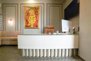 a reception desk in a hotel room with a painting on the wall at Shivashish Resort in Indore